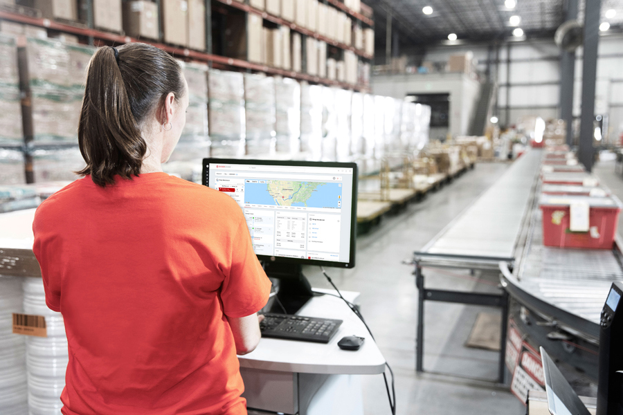 employee at warehouse facilty in front of a computer